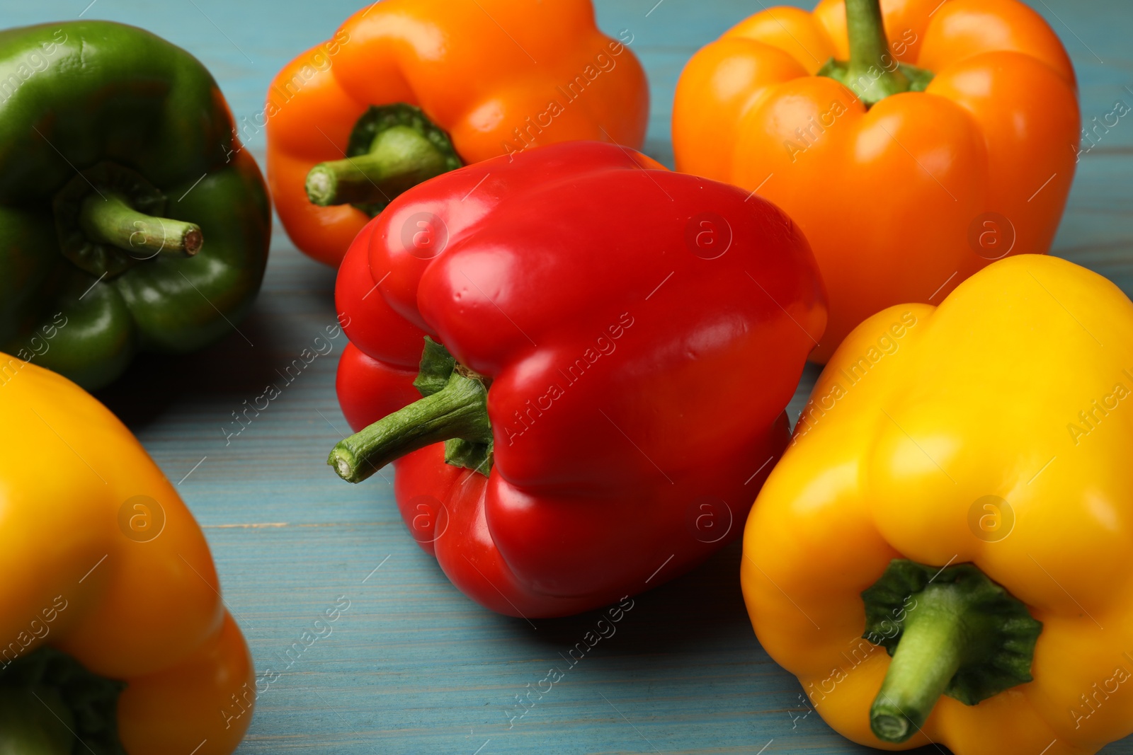 Fresh colorful bell peppers on blue wooden table, closeup Photo of Fresh colorful bell peppers on blue wooden table, closeup