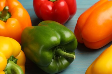 Photo of Fresh colorful bell peppers on blue wooden table, closeup