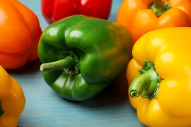 Photo of Fresh colorful bell peppers on blue wooden table, closeup