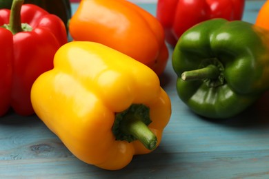Photo of Fresh colorful bell peppers on blue wooden table, closeup