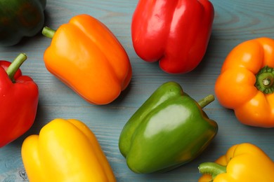Photo of Fresh colorful bell peppers on blue wooden table, flat lay