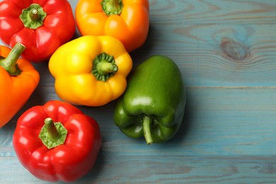 Photo of Fresh colorful bell peppers on blue wooden table, flat lay