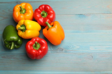 Photo of Fresh colorful bell peppers on blue wooden table, flat lay. Space for text