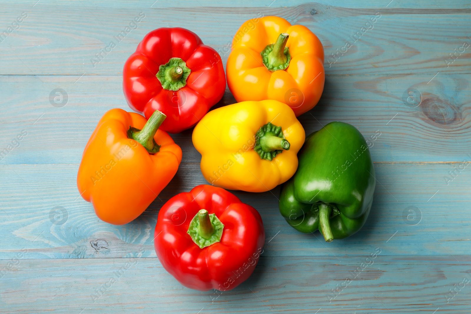 Fresh colorful bell peppers on blue wooden table, flat lay Photo of Fresh colorful bell peppers on blue wooden table, flat lay