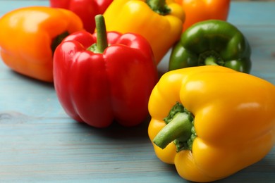 Photo of Fresh colorful bell peppers on blue wooden table, closeup