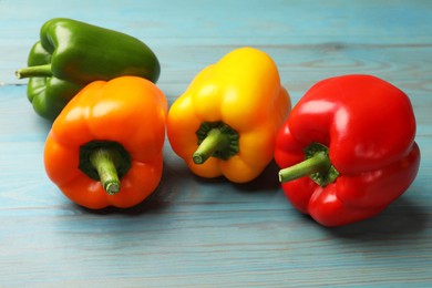 Photo of Fresh colorful bell peppers on blue wooden table, closeup