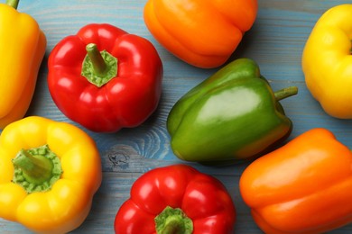 Photo of Fresh colorful bell peppers on blue wooden table, flat lay