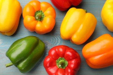 Photo of Fresh colorful bell peppers on blue wooden table, flat lay