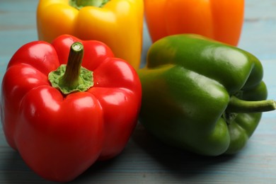 Photo of Fresh colorful bell peppers on blue wooden table, closeup