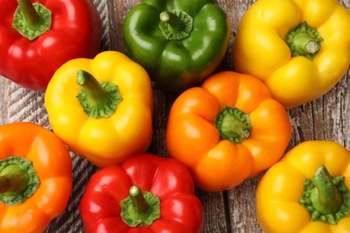 Photo of Fresh colorful bell peppers on wooden table, flat lay