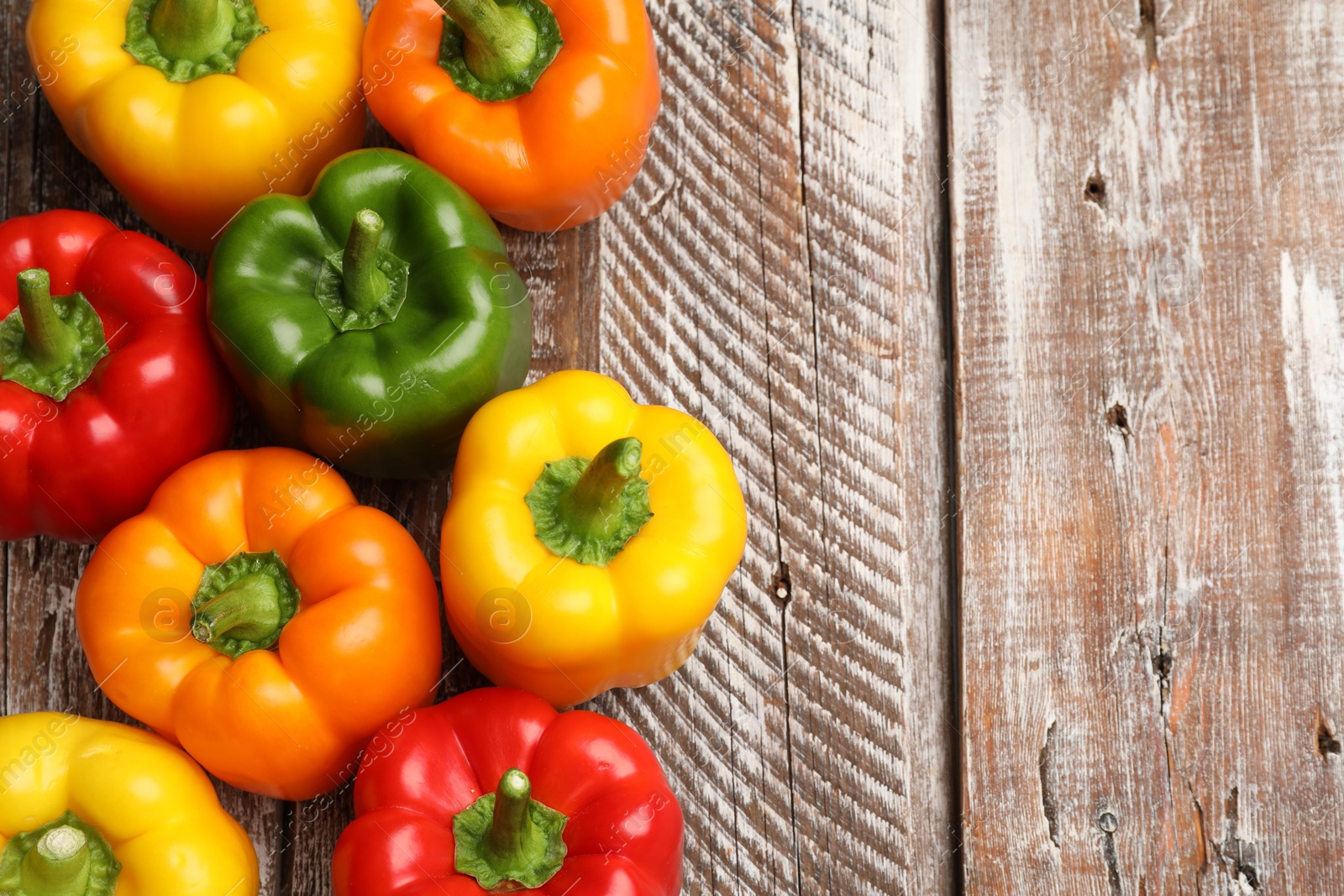 Fresh colorful bell peppers on wooden table, flat lay. Space for text Photo of Fresh colorful bell peppers on wooden table, flat lay. Space for text
