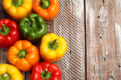 Photo of Fresh colorful bell peppers on wooden table, flat lay. Space for text