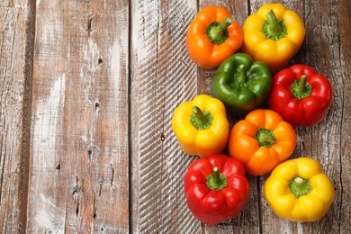 Photo of Fresh colorful bell peppers on wooden table, flat lay. Space for text