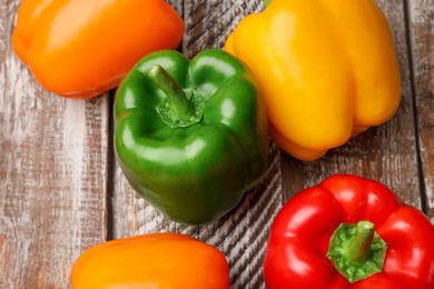 Photo of Fresh colorful bell peppers on wooden table, flat lay