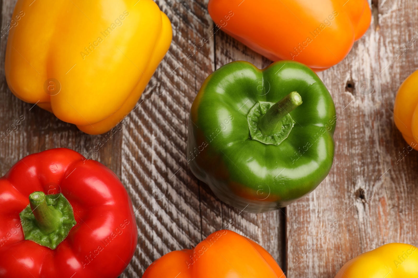 Fresh colorful bell peppers on wooden table, flat lay Photo of Fresh colorful bell peppers on wooden table, flat lay
