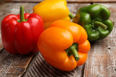 Photo of Fresh colorful bell peppers on wooden table, closeup