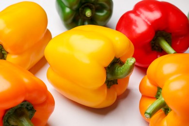 Photo of Fresh colorful bell peppers on light table, closeup