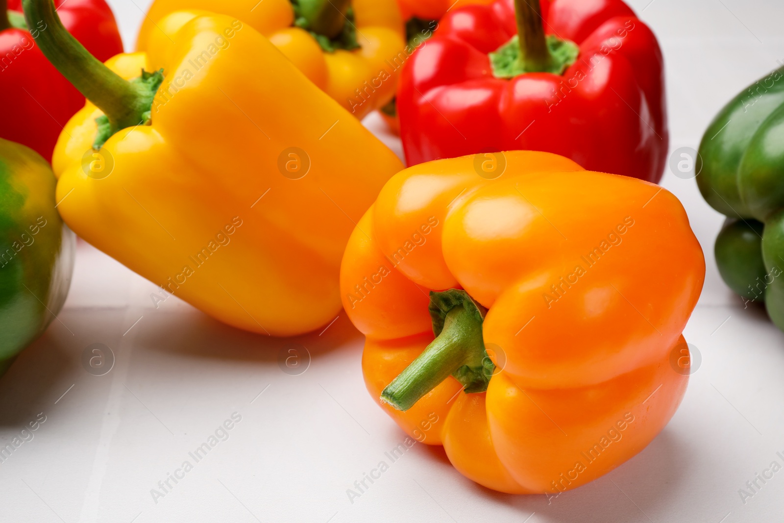 Fresh colorful bell peppers on light table, closeup Photo of Fresh colorful bell peppers on light table, closeup