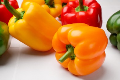 Photo of Fresh colorful bell peppers on light table, closeup