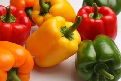 Photo of Fresh colorful bell peppers on light table, closeup