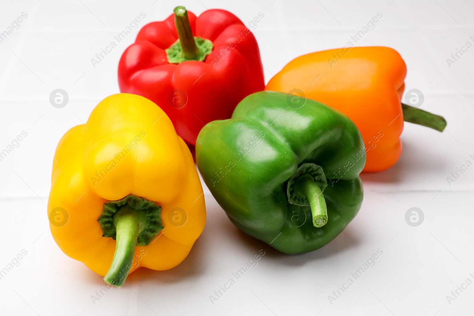 Fresh colorful bell peppers on white table, closeup Photo of Fresh colorful bell peppers on white table, closeup