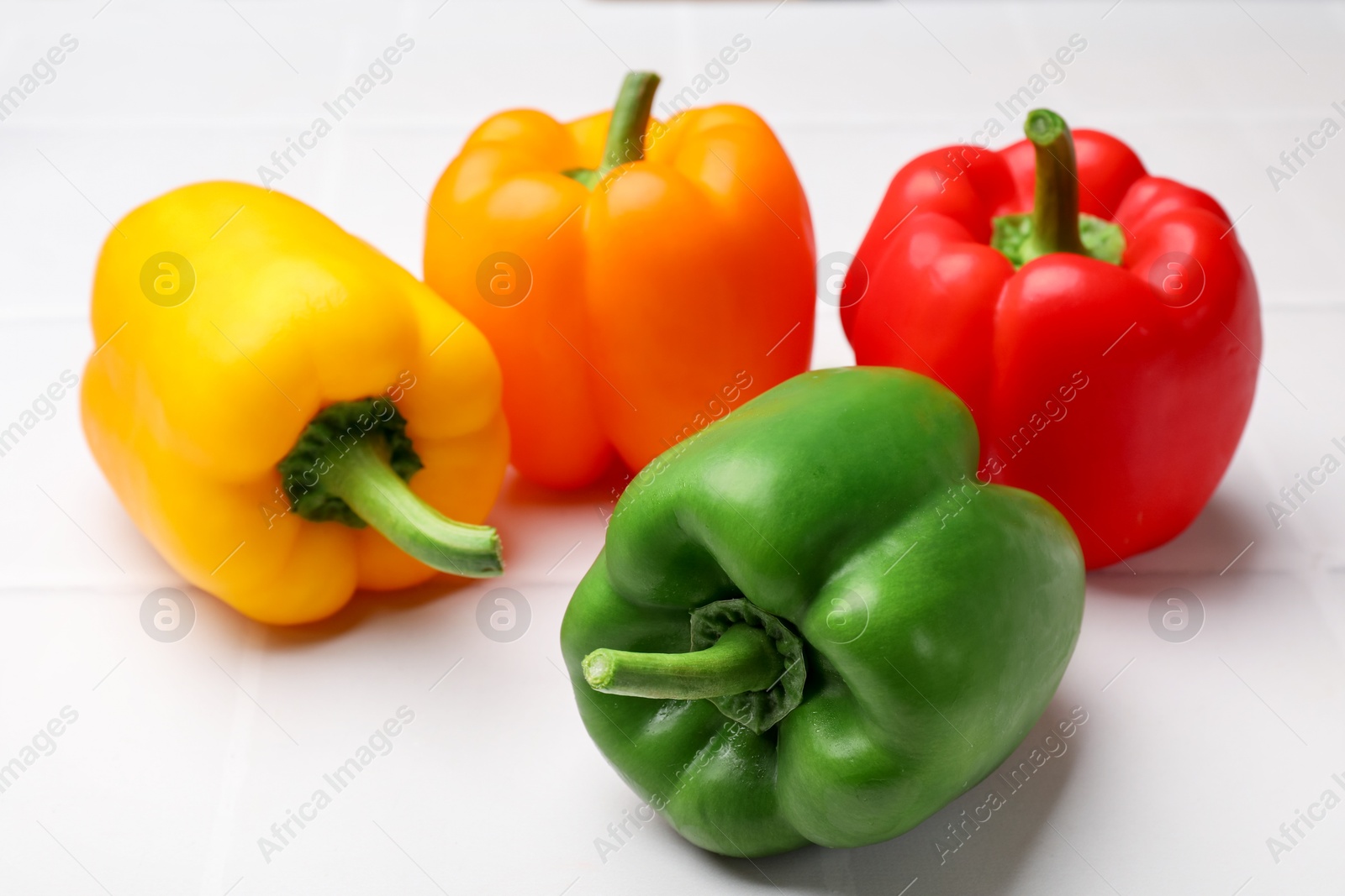 Fresh colorful bell peppers on white table, closeup Photo of Fresh colorful bell peppers on white table, closeup