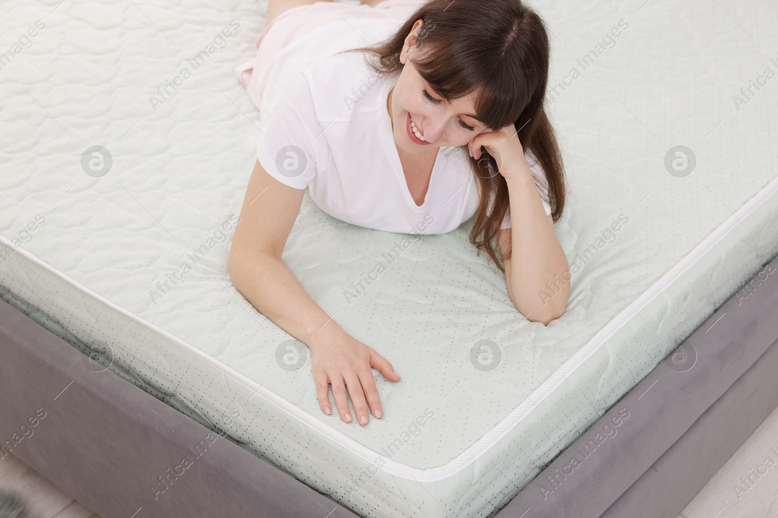 Beautiful woman lying on soft mattress at home Photo of Beautiful woman lying on soft mattress at home