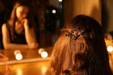 Photo of Woman with clips on her beautiful hair indoors, closeup