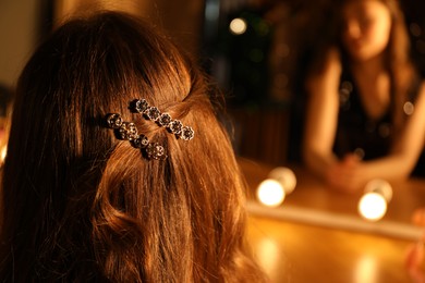 Photo of Woman with clips on her beautiful hair indoors, closeup