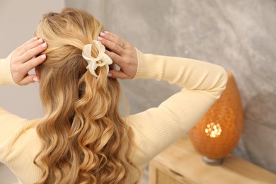 Photo of Woman with beautiful hair curls indoors, back view