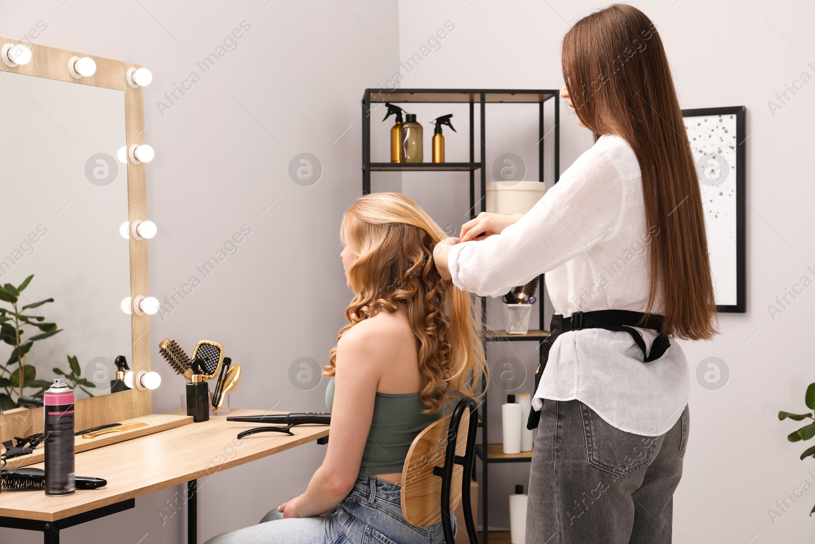 Professional hairdresser styling woman's hair in salon Photo of Professional hairdresser styling woman's hair in salon