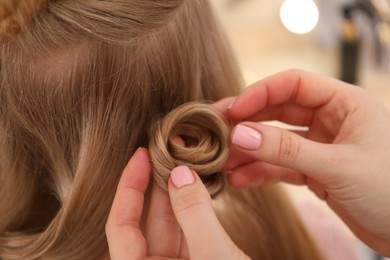 Photo of Hairdresser styling woman's hair in salon, closeup