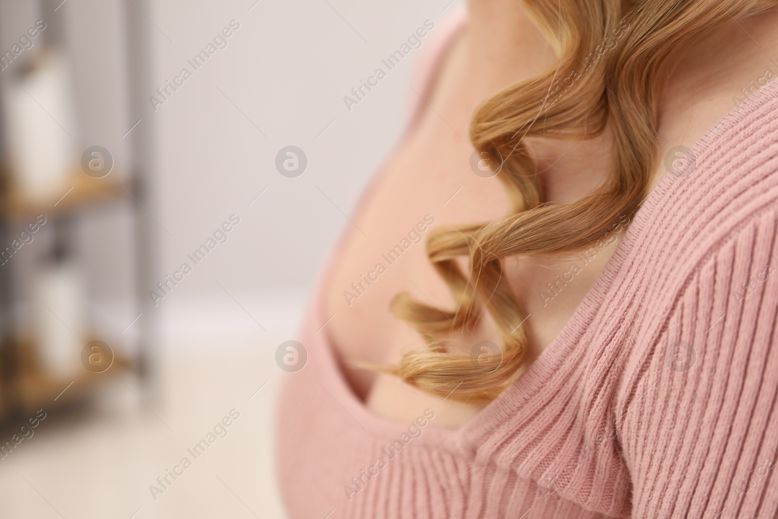Photo of Woman with beautiful hair curls indoors, closeup. Space for text