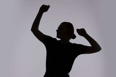 Photo of Silhouette of woman posing on grey background