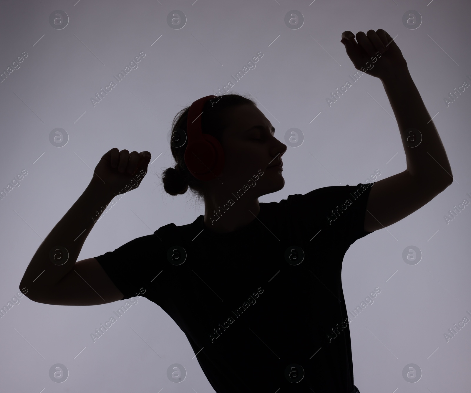 Silhouette of woman posing on grey background Photo of Silhouette of woman posing on grey background