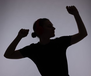 Photo of Silhouette of woman posing on grey background