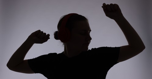 Photo of Silhouette of woman posing on grey background
