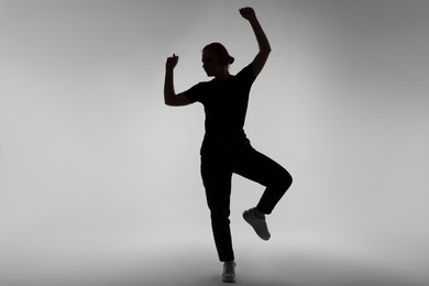 Photo of Silhouette of woman posing on grey background