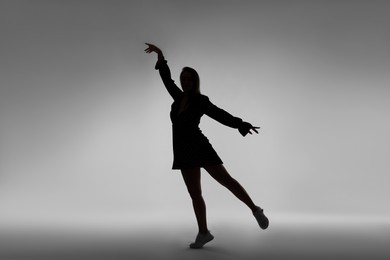 Photo of Silhouette of woman posing on grey background