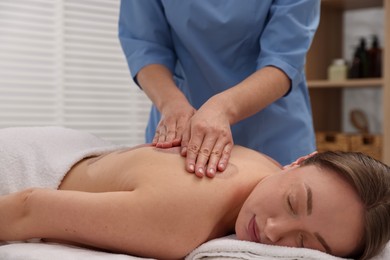 Photo of Cupping therapy. Woman receiving professional massage in spa salon