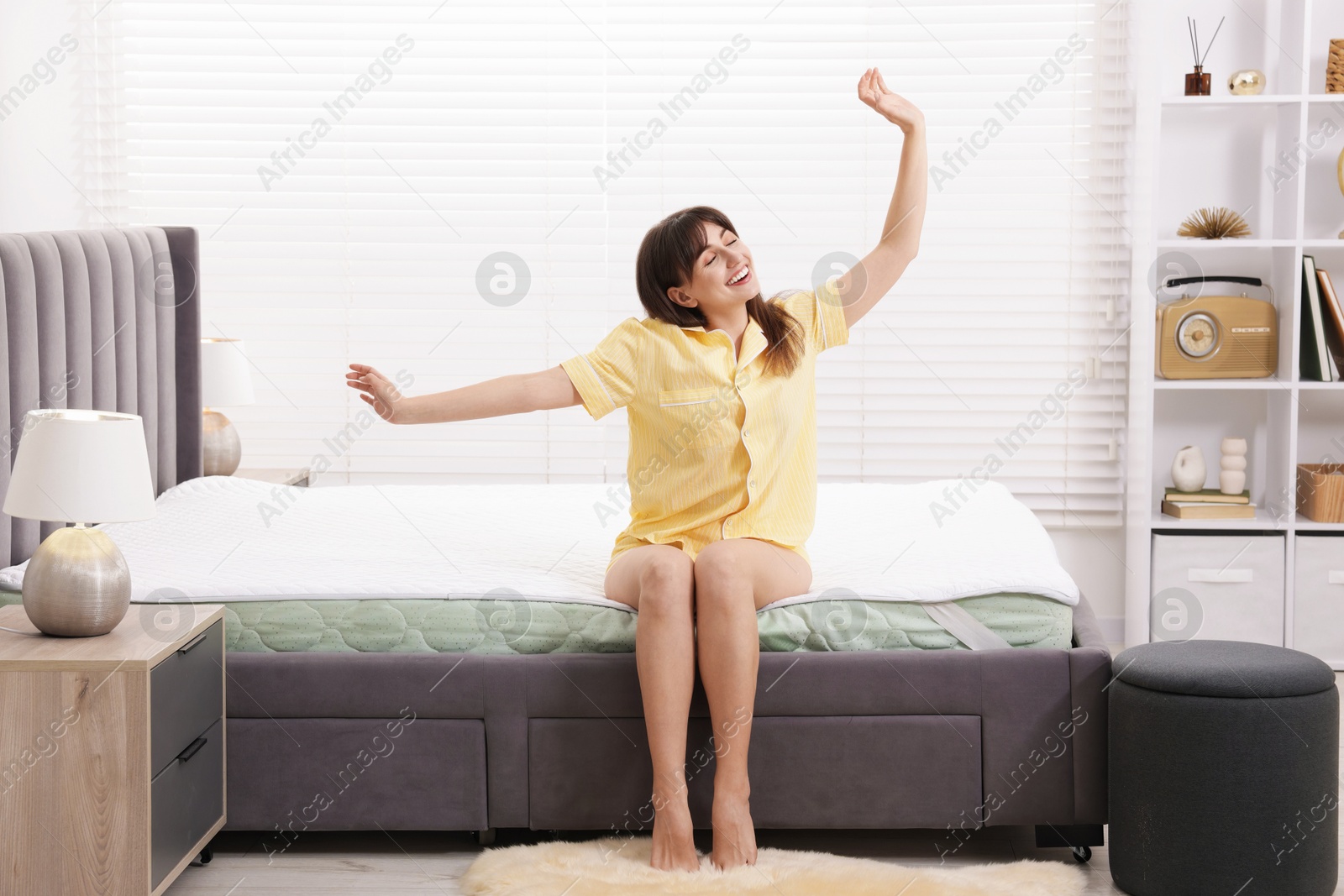 Smiling woman stretching on bed at home Photo of Smiling woman stretching on bed at home