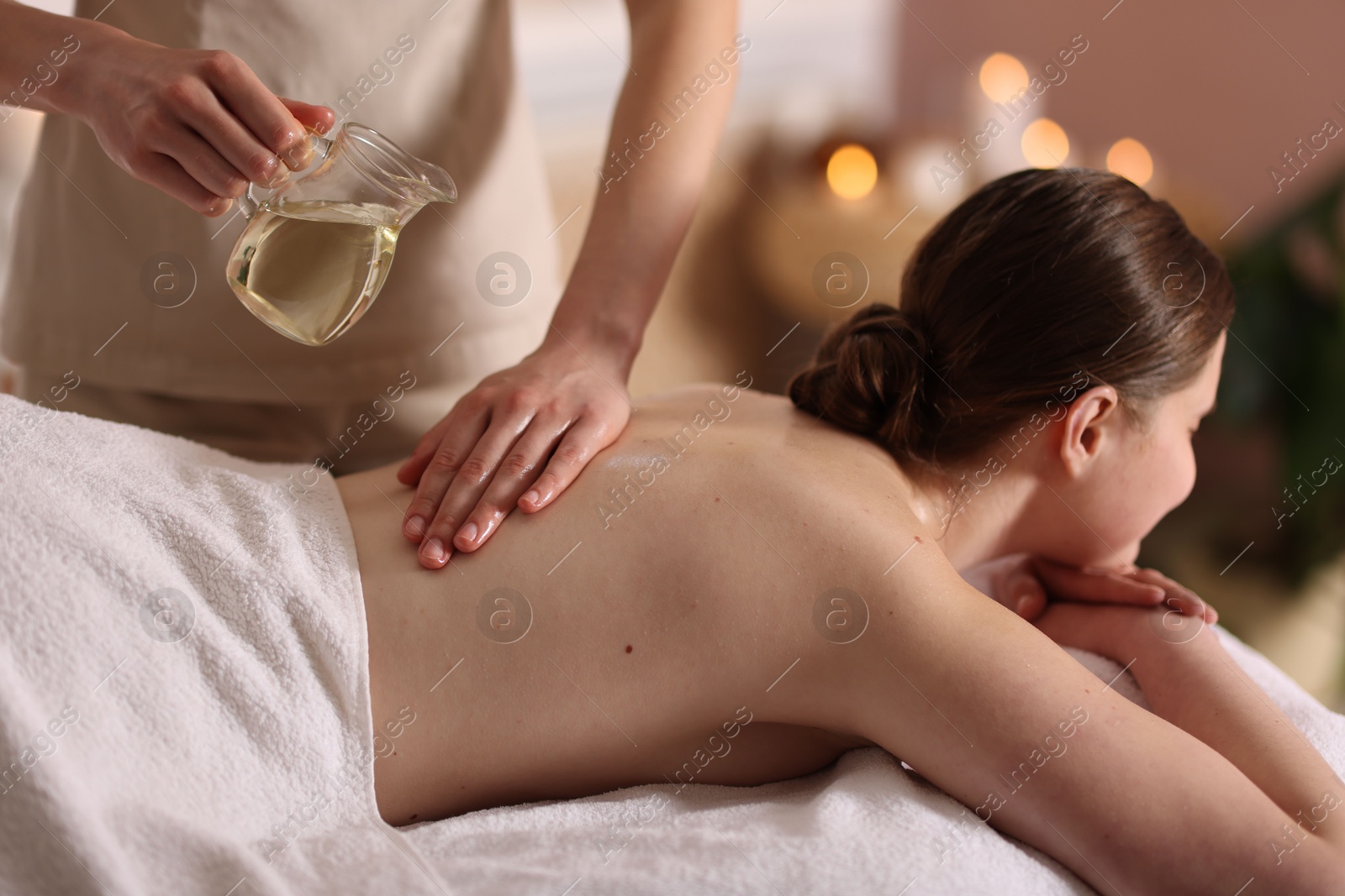 Woman receiving back massage with oil in spa salon Photo of Woman receiving back massage with oil in spa salon