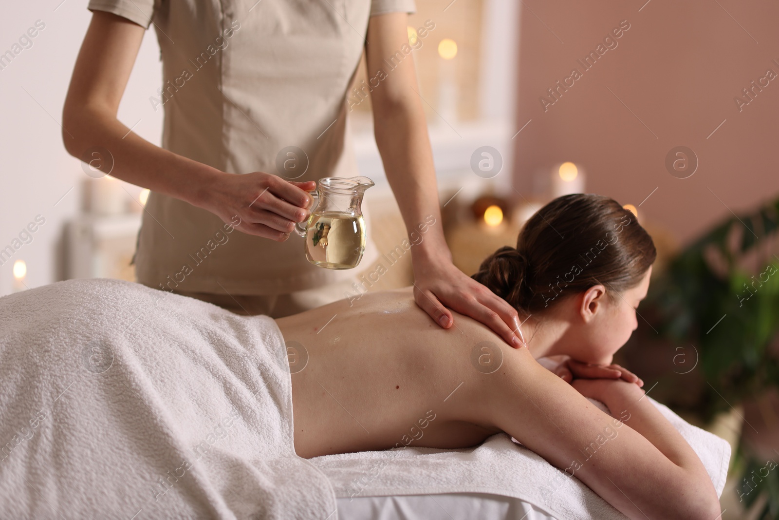 Woman receiving back massage with oil in spa salon Photo of Woman receiving back massage with oil in spa salon