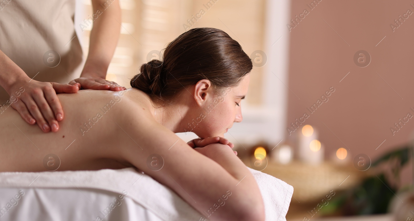 Woman receiving back massage with oil in spa salon, space for text Photo of Woman receiving back massage with oil in spa salon, space for text
