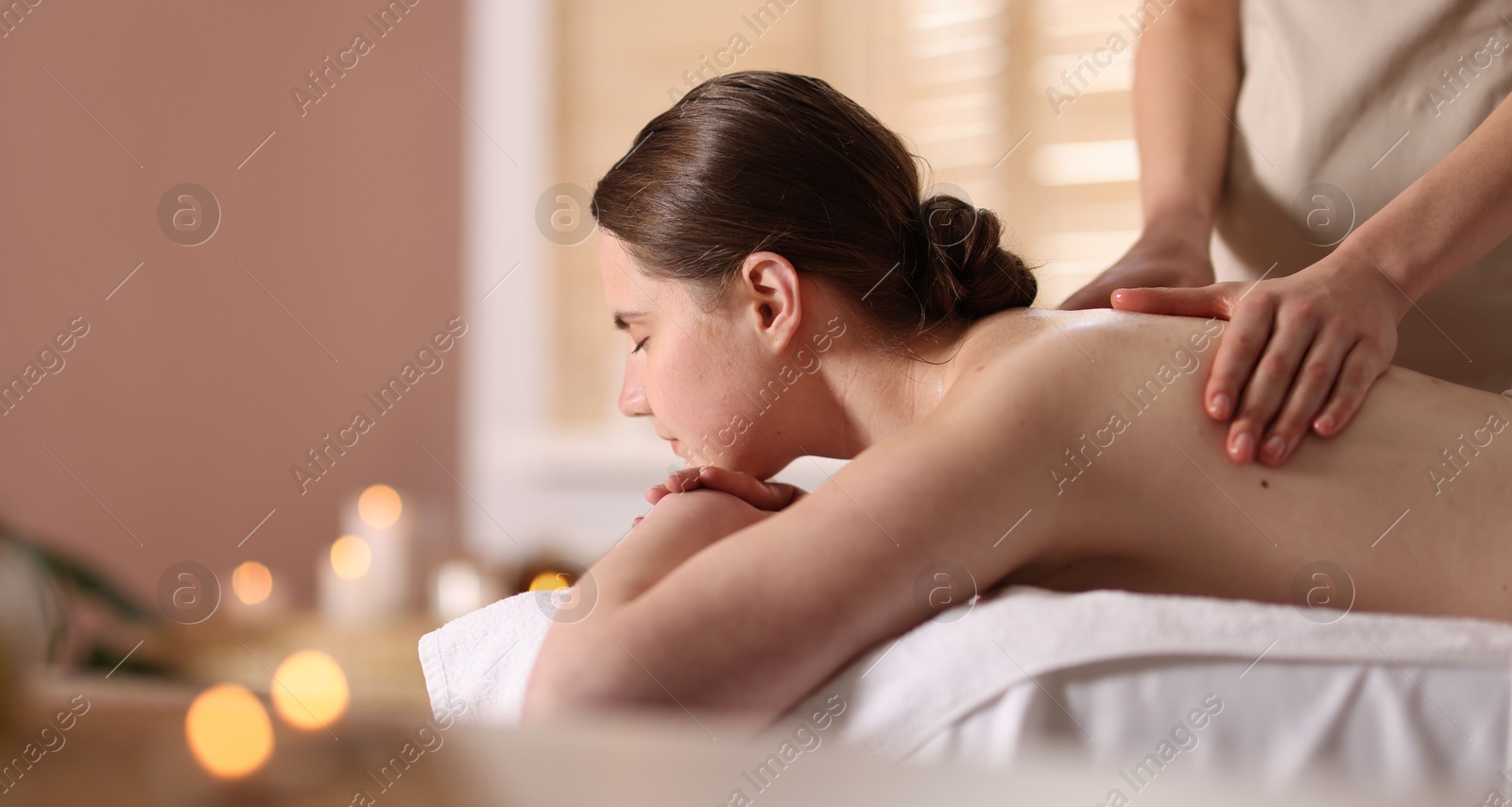 Woman receiving back massage with oil in spa salon, space for text Photo of Woman receiving back massage with oil in spa salon, space for text