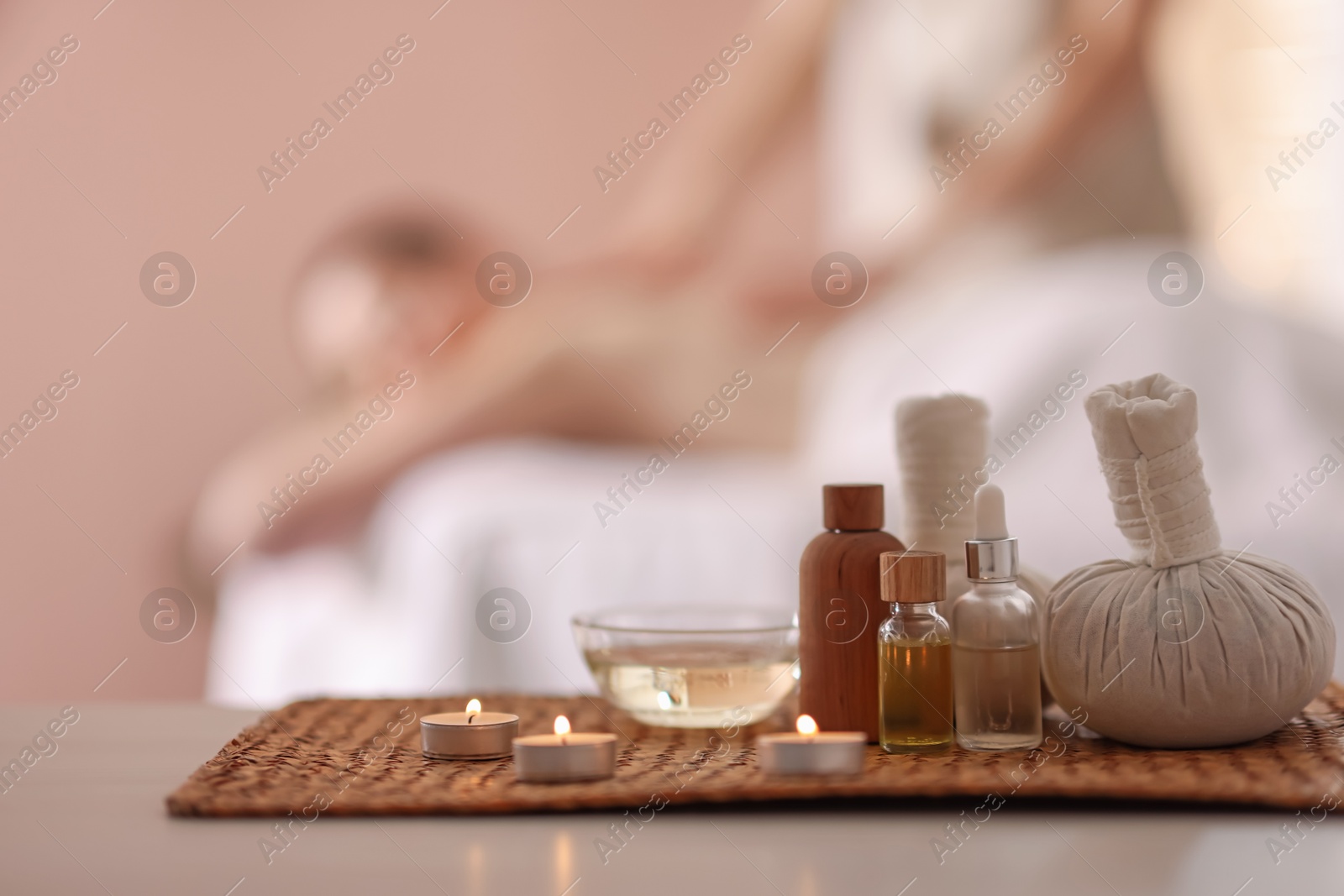 Photo of Woman receiving back massage in spa salon, focus on essential oils and burning candles