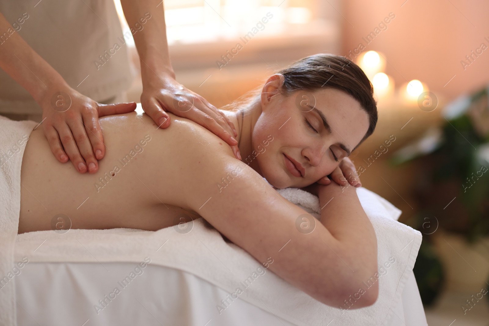 Woman receiving back massage with oil in spa salon Photo of Woman receiving back massage with oil in spa salon