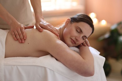 Photo of Woman receiving back massage with oil in spa salon