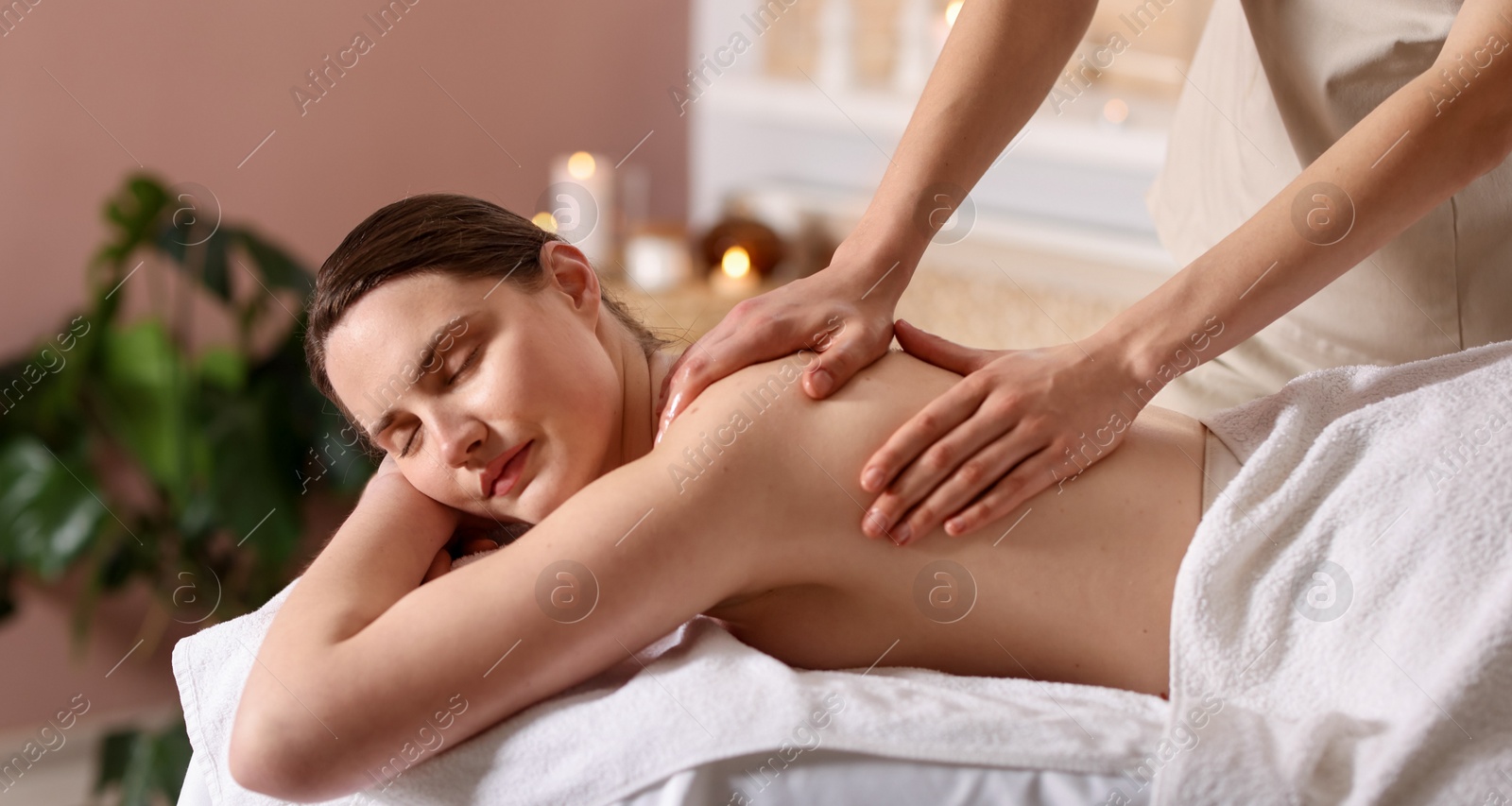 Woman receiving back massage with oil in spa salon Photo of Woman receiving back massage with oil in spa salon