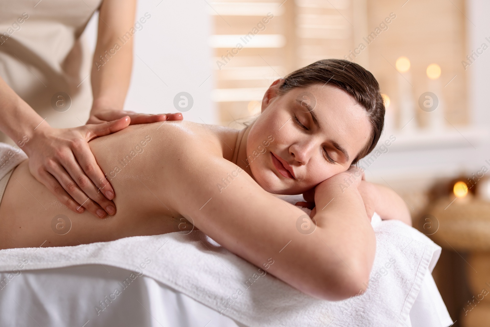 Woman receiving back massage with oil in spa salon Photo of Woman receiving back massage with oil in spa salon